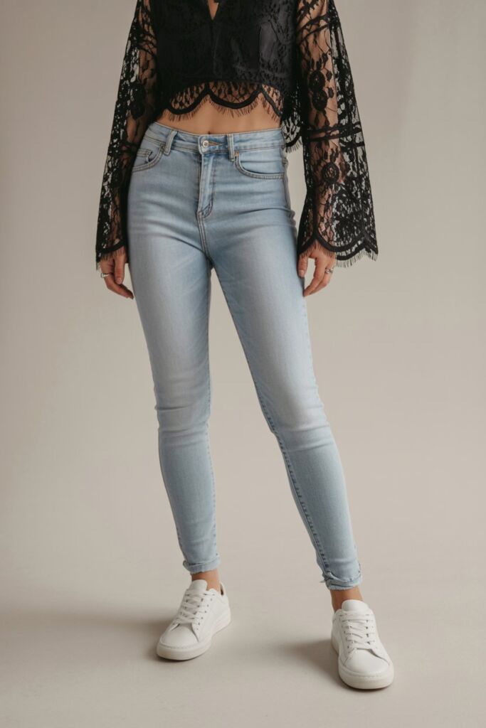 Black lace crop top with light-wash skinny jeans and white leather sneakers