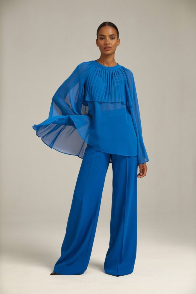 Model in flowy chiffon royal blue blouse with wide-leg trousers