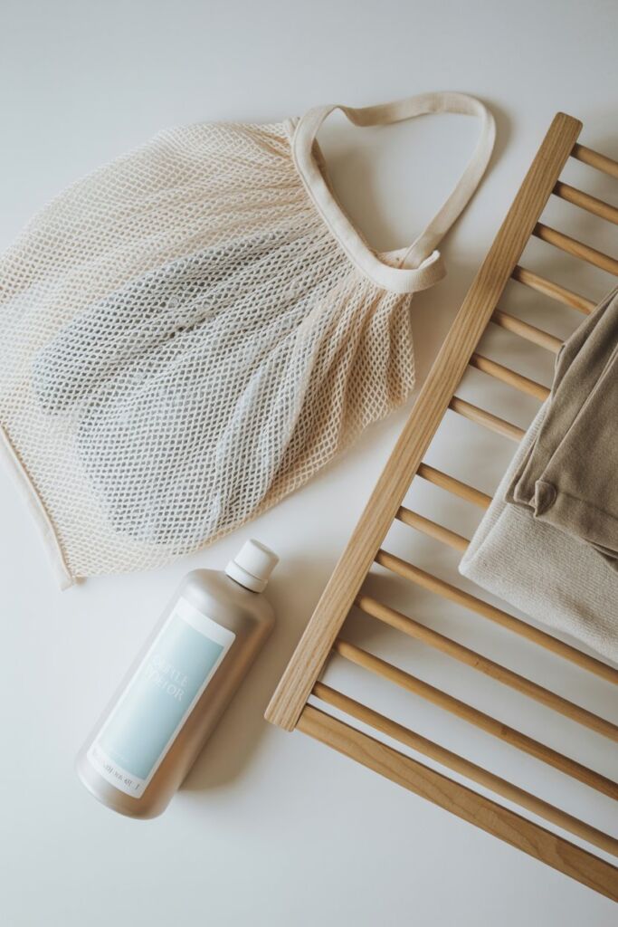 Clothing care flat lay — mesh bag, air dry rack, gentle detergent